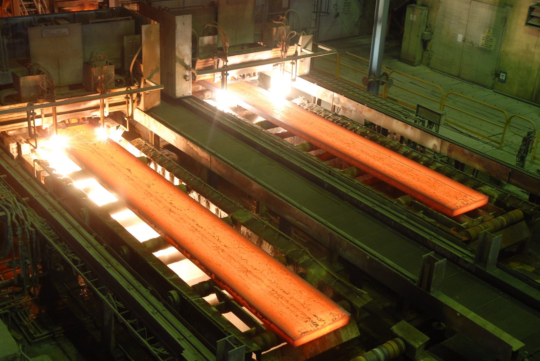 Red-hot steel slabs moving down a continuous casting line
